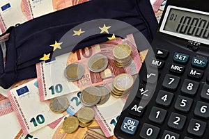 Close-up of a calculator, euro bills and diy facemask, designed as an European Union flag.