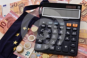 Close-up of a calculator, euro bills and diy facemask, designed as an European Union flag.