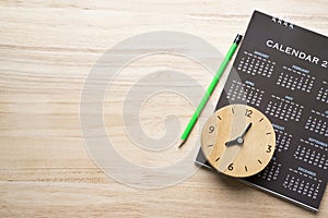 Close up of calendar, pencil and clock on the table