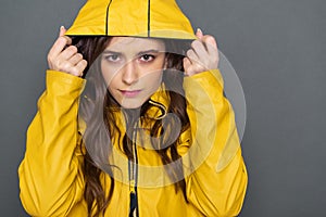 Close up of calm Caucasian girl dressed in yellow raincoat in studio