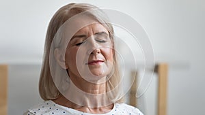 Close up calm peaceful mature woman relaxing with closed eyes photo