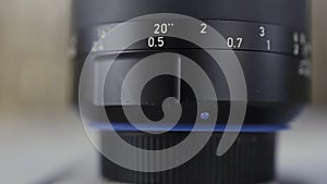 Close up of camera lens. Action. Details of black plastic photo and video new camera body on blurred background.