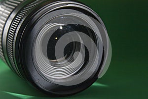 Close-up camera lens on a dark green background