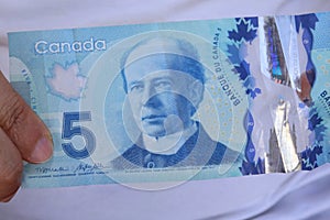 A close up of Canadian money- $5.00 bill