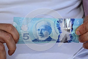 A close up of Canadian money- $5.00 bill