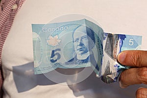A close up of Canadian money- $5.00 bill