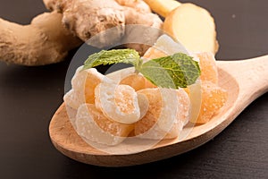 Close up candied crystallized ginger candy pieces on wooden spoon