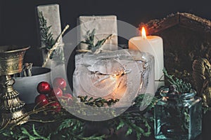 Close up of a candle burning in the ice. Festive Yule winter solstice Christmas set up on wiccan witch altar
