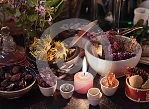 Close up of candle, herbs, flowers and berries