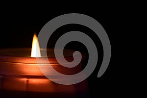 Close up of a candle light on dark background.