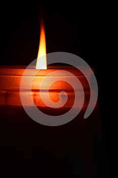 Close up of a candle light on dark background.