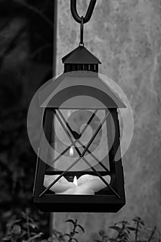 Close up of a Candlelight Lamp with a lit candle in the cemetery. Black and White digital manipulation.