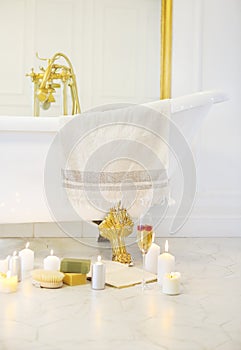 Close up of candles, book, glass of champagne by the bath