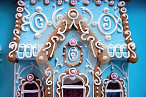 a close-up of candy window details on a gingerbread house viewed against a blue backdrop