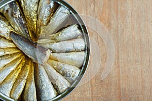 A close-up of a canned sardine on rustic weathered wood background with copy space.