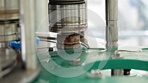 Close-up of the capping of plastic five-liter bottles. Production of drinking water at a food processing plant