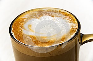 Close up of cappuccino in brown cup on table