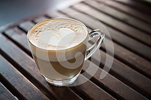 Close up of cappuccino cup with heart shaped milk pattern at cafe. a cup of coffee art.