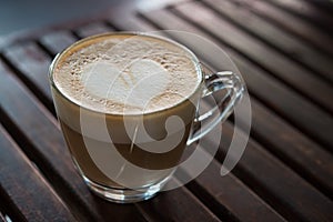 Close up of cappuccino cup with heart shaped milk pattern at cafe. a cup of coffee art.