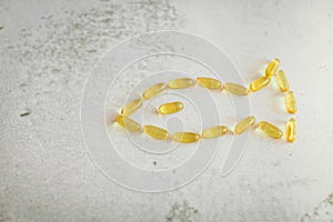 Close up capsules laid out in the form of fish. Fish from gold capsules of DHA omega-3