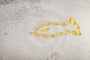 Close up capsules laid out in the form of fish. Fish from gold capsules of DHA omega-3