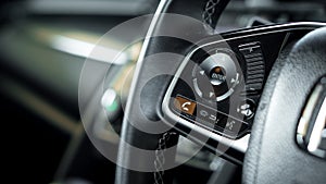 Close up car cruise control on car steering wheel with blurred c