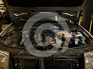 Close-up of a car engine details, motor of a car with open hood. Auto service, maintenance, warranty repair concept in car repair