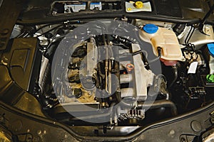 Close-up. Car engine details, motor of a car with open hood. Auto service, maintenance, warranty repair concept in car repair