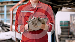 Close-up car inspection book in the hand of a mechanic Mechanic checking what is written from the vehicle