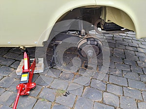 Close-up of a car jacked up for tire and wheel replacement.