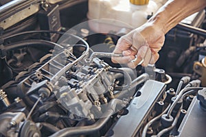 Close up Car Mechanic man hands repairing car auto repair shop. Man hands fixing machinery vehicle mechanical service. open
