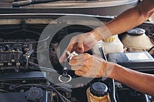 Close up Car Mechanic man hands repairing car auto repair shop. Man hands fixing machinery vehicle mechanical service. open