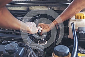 Close up Car Mechanic man hands repairing car auto repair shop. Man hands fixing machinery vehicle mechanical service. open