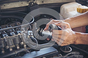 Close up Car Mechanic man hands repairing car auto repair shop. Man hands fixing machinery vehicle mechanical service. open