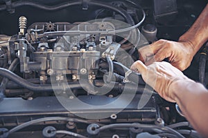 Close up Car Mechanic man hands repairing car auto repair shop. Man hands fixing machinery vehicle mechanical service. open