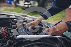 Close up Car Mechanic man hands repairing car auto repair shop. Man hands fixing machinery vehicle mechanical service. open