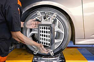 Close-up of car mechanics installing sensors during suspension adjustment