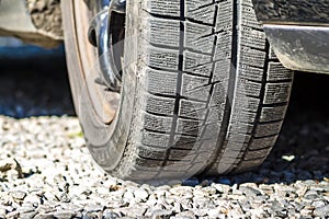 Close up of car& x27;s winter tyre tread on the gravel road