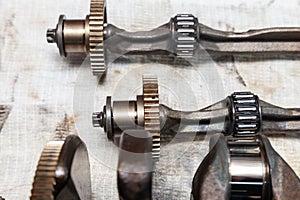 Close-up on a car shaft with gears and bearings removed for replacement on a workbench in a repair shop for vehicles. Auto service