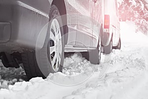 Close up on car tires parked in messy deep snow cars