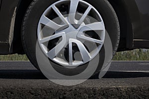 Close up of a car wheel on the ground.