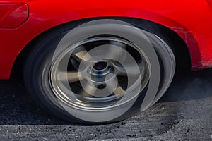 Close up car wheel with smoke on the asphalt road speed track, Car wheel drifting and smoking on track, Car wheel spinning