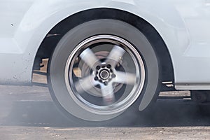 Close up car wheel with smoke on the asphalt road speed track, Car wheel drifting and smoking on track, Car wheel spinning