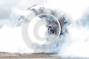 Close up car wheel with smoke on the asphalt road speed track, Car wheel drifting and smoking on track, Car wheel spinning