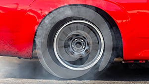 Close up car wheel with smoke on the asphalt road speed track, Car wheel drifting and smoking on track, Car wheel spinning