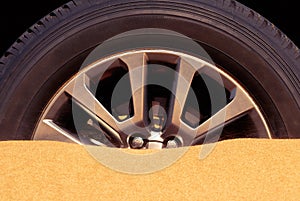 Pohľad zblízka na auto kolo prilepené v piesok v púšť 