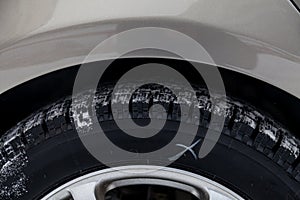 Close-up a car wheel with tread Studded tires with little wear during filming for a safe birth in snow and ice