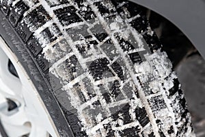 Close-up on a car wheel with tread Studded tires with little wear during filming for a safe birth in snow and ice