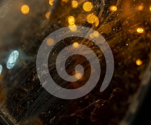 Close-up of car window with reflections of lanterns in winter evening, with child's toy