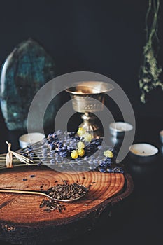 Close up of caraway seeds in a gold brass colored tea spoon, spread on a peace of wood from tree trunk